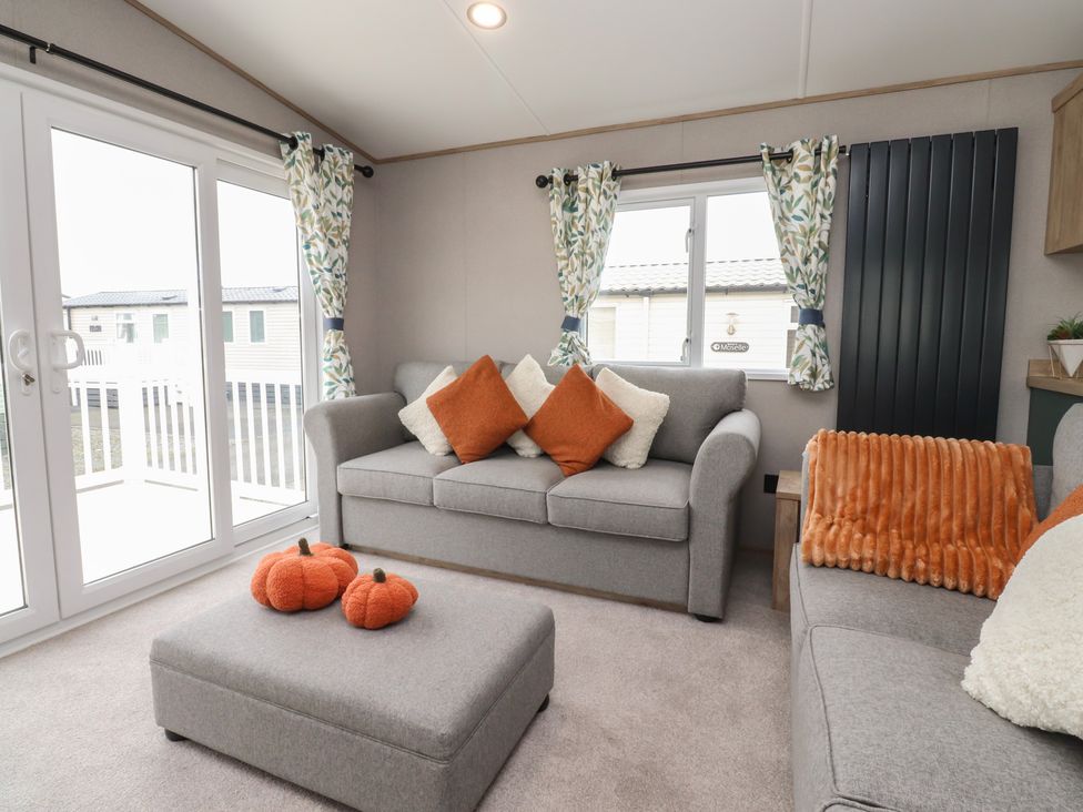 A living room with a gray couch and ottoman at The Retreat in Morecambe