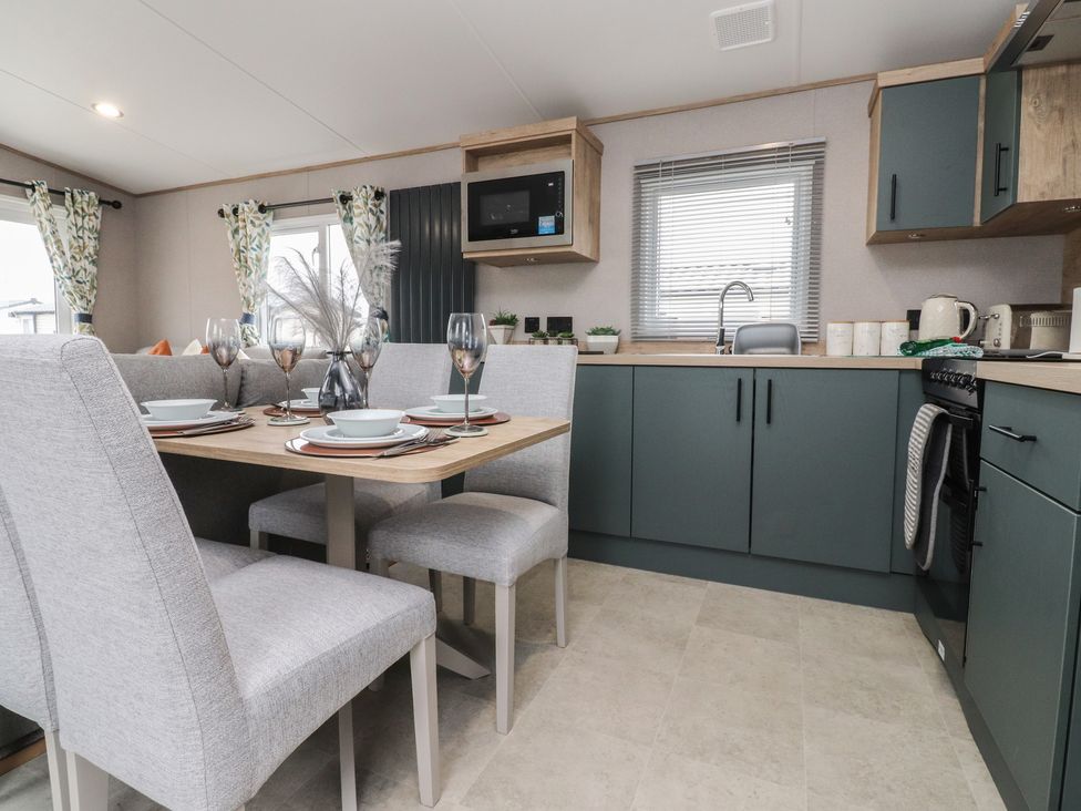 A kitchen with dining area and modern appliances at The Retreat in Morecambe