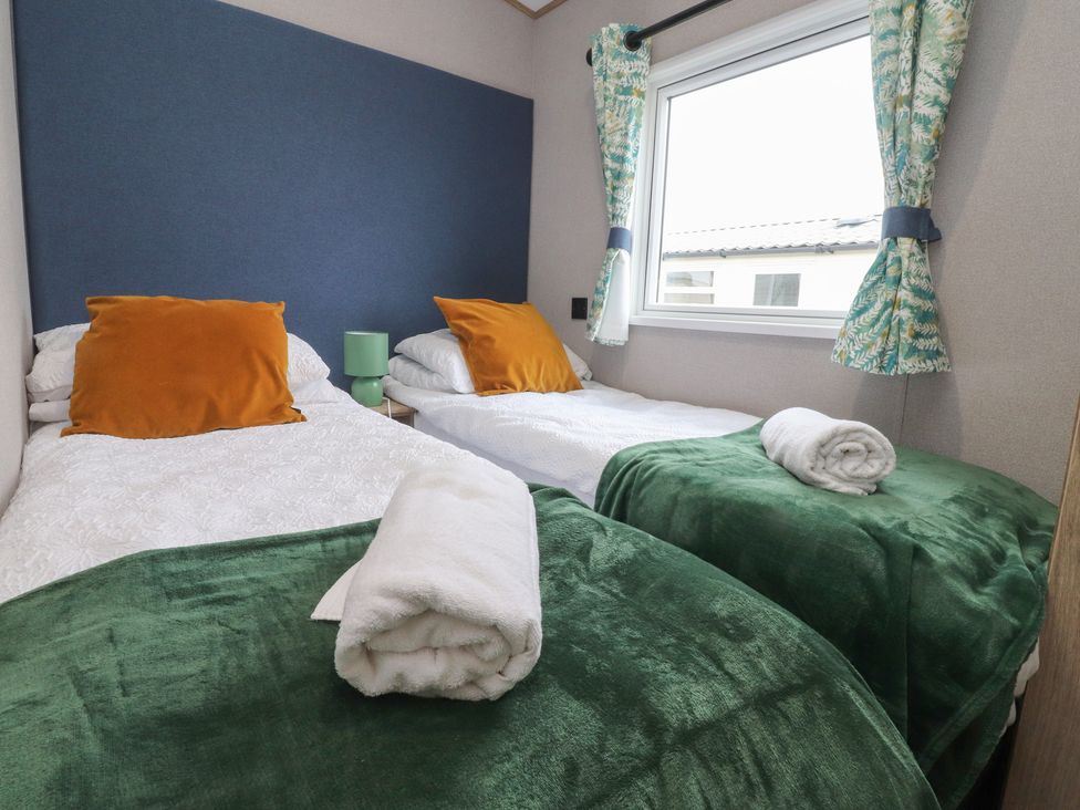 A bedroom with two beds and a window at The Retreat in Morecambe