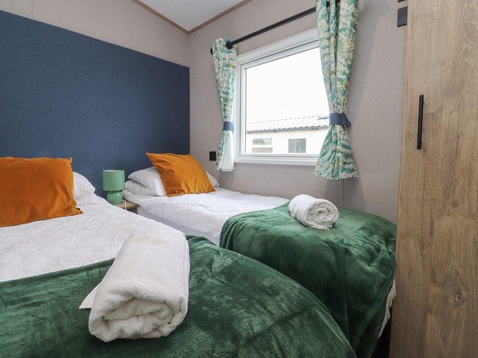 A bedroom with two single beds and a window at The Retreat in Morecambe