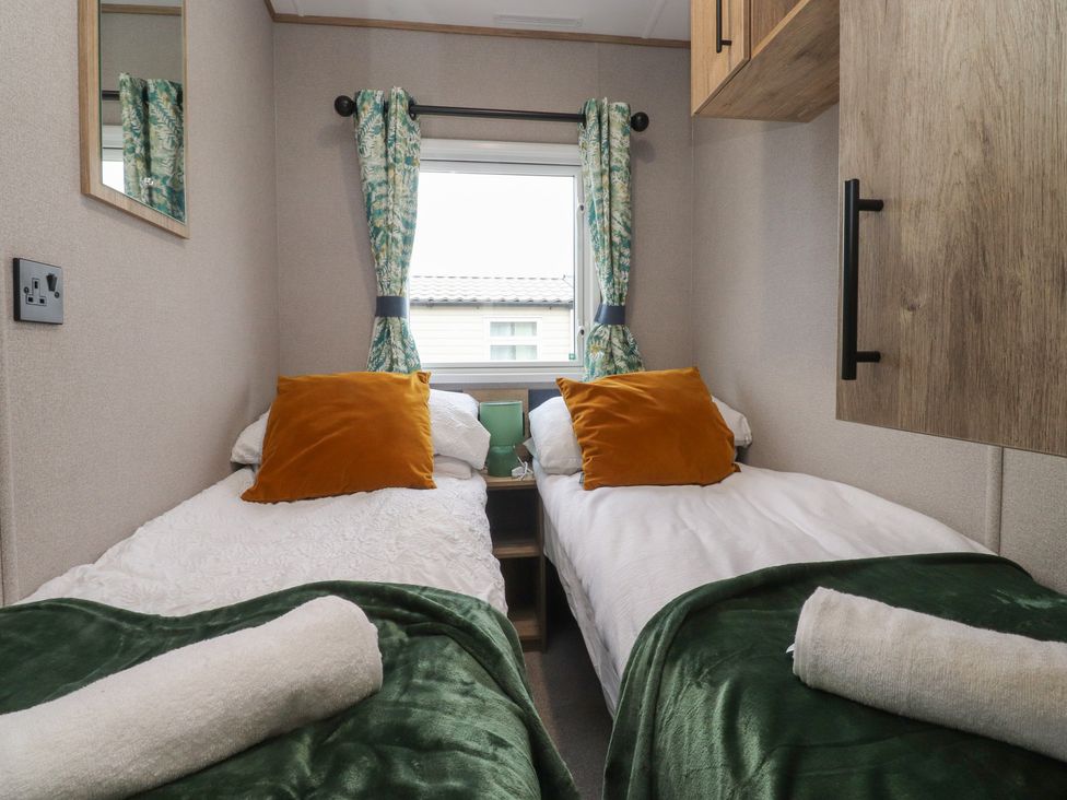 A bedroom with twin beds and a mirror at The Retreat in Morecambe