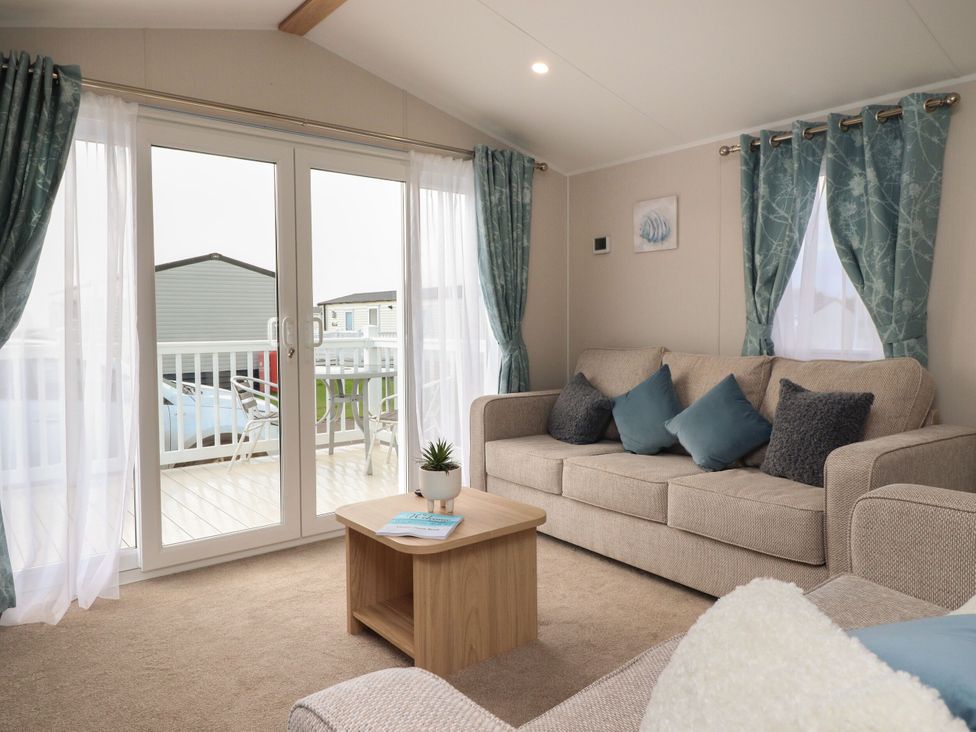 A living room with a sofa and coffee table at Poppy Lodge in Morecambe
