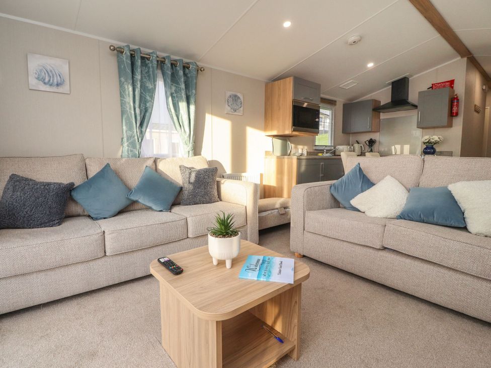 A living room with a coffee table and sofas at Poppy Lodge in Morecambe