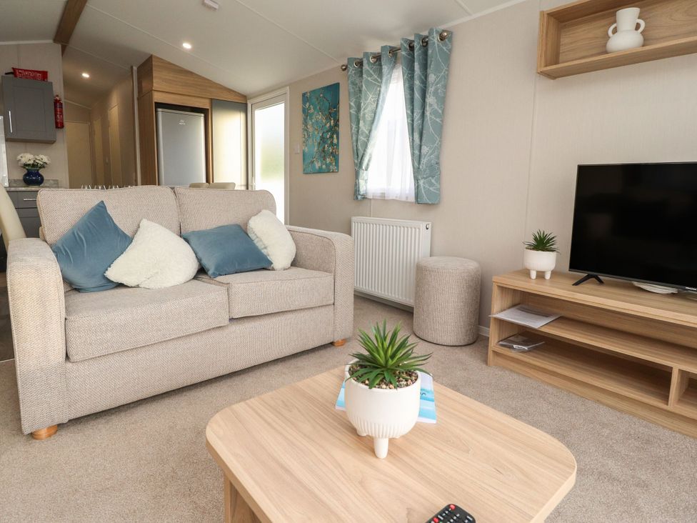 A living room with a sofa and television at Poppy Lodge in Morecambe