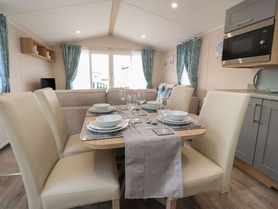 A dining area with a table set for a meal at Poppy Lodge in Morecambe