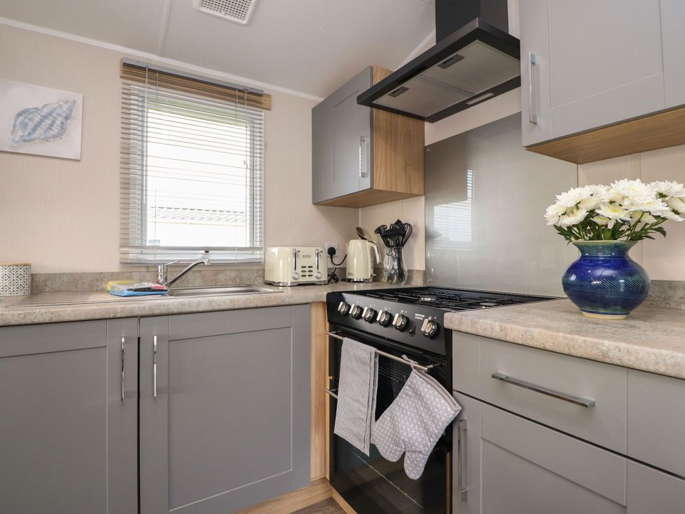 A kitchen with a stove and sink at Poppy Lodge in Morecambe