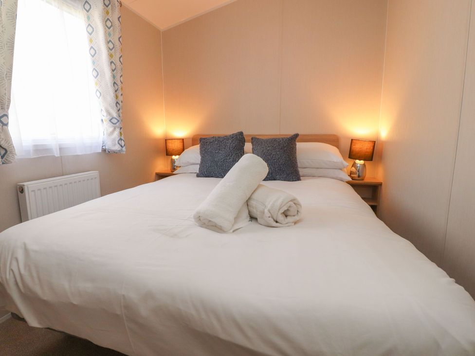 A bedroom with a bed and pillows at Poppy Lodge Morecambe