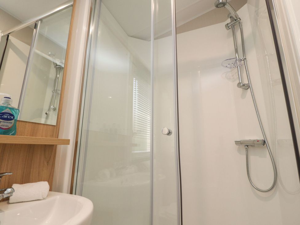 A bathroom with a shower and sink at Poppy Lodge in Morecambe