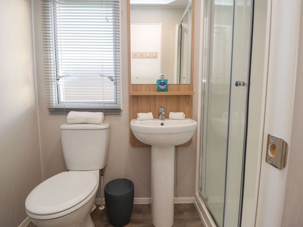 A bathroom with a toilet, sink, and shower at Poppy Lodge in Morecambe