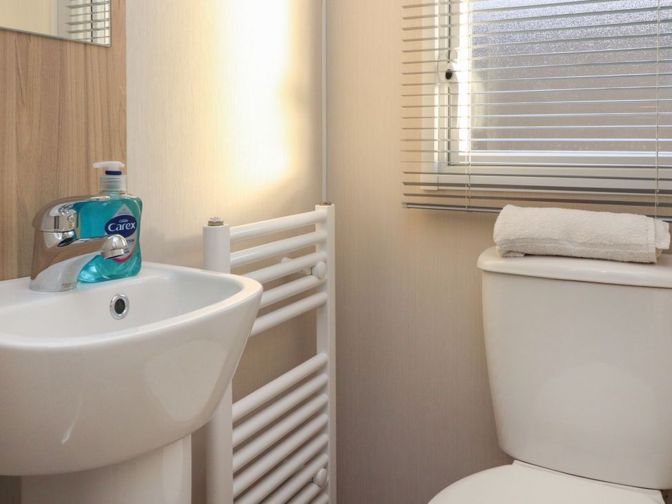 A bathroom with a sink and a toilet at Poppy Lodge Morecambe
