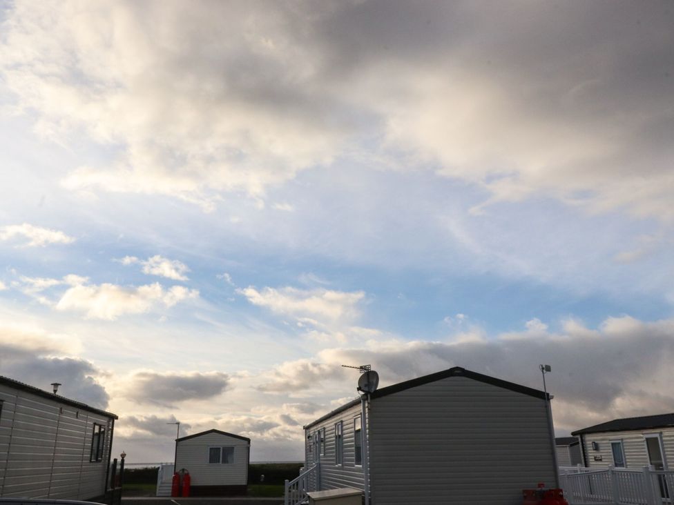 An outdoor view of mobile homes under a cloudy sky at Poppy Lodge in Morecambe