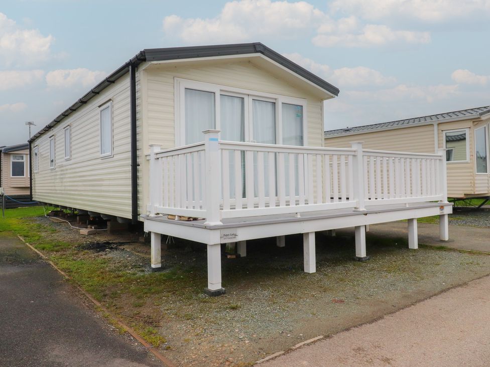 A mobile home with a deck at Poppy Lodge in Heysham