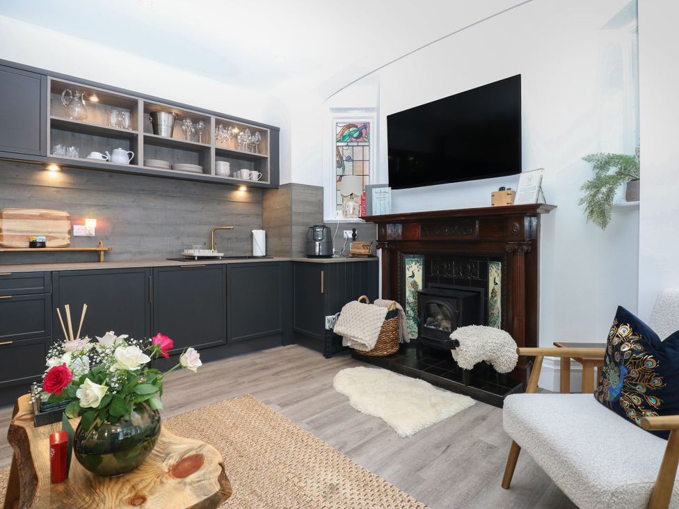 A kitchen with furniture and appliances at The Magnolia in Rhos-On-Sea