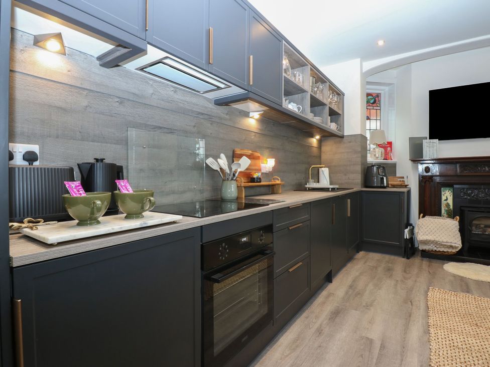A kitchen with cabinets and an oven at The Magnolia in Rhos-On-Sea