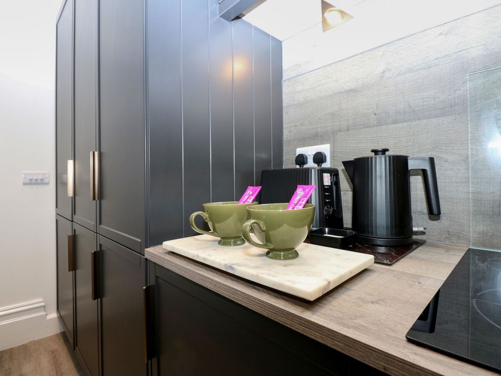 A kitchen with kettle and cups on a countertop at The Magnolia in Rhos-On-Sea