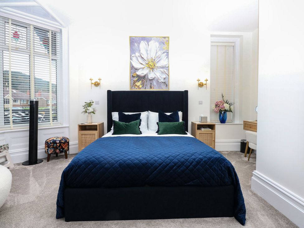 A bedroom with a bed and bedside table at The Magnolia in Rhos-On-Sea