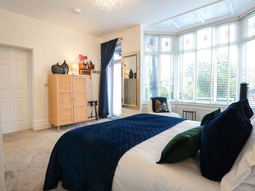 A bedroom with a bed and wardrobe at The Magnolia in Rhos-On-Sea