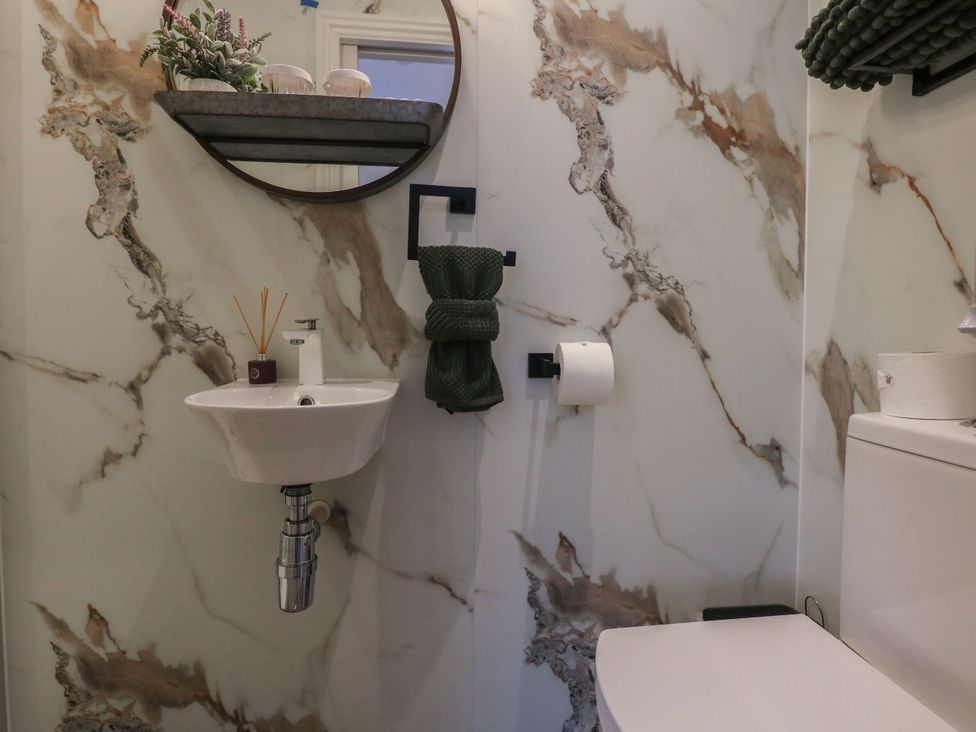 A bathroom with a sink and toilet at The Magnolia in Rhos-On-Sea