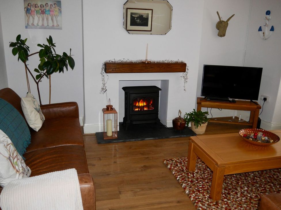 A living room with a fireplace and a television at Anchor Cottage in Cleethorpes
