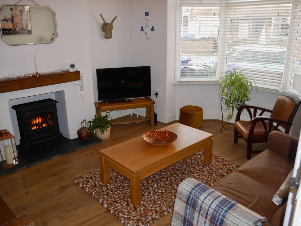 A living room with a television and fireplace at Anchor Cottage in Cleethorpes