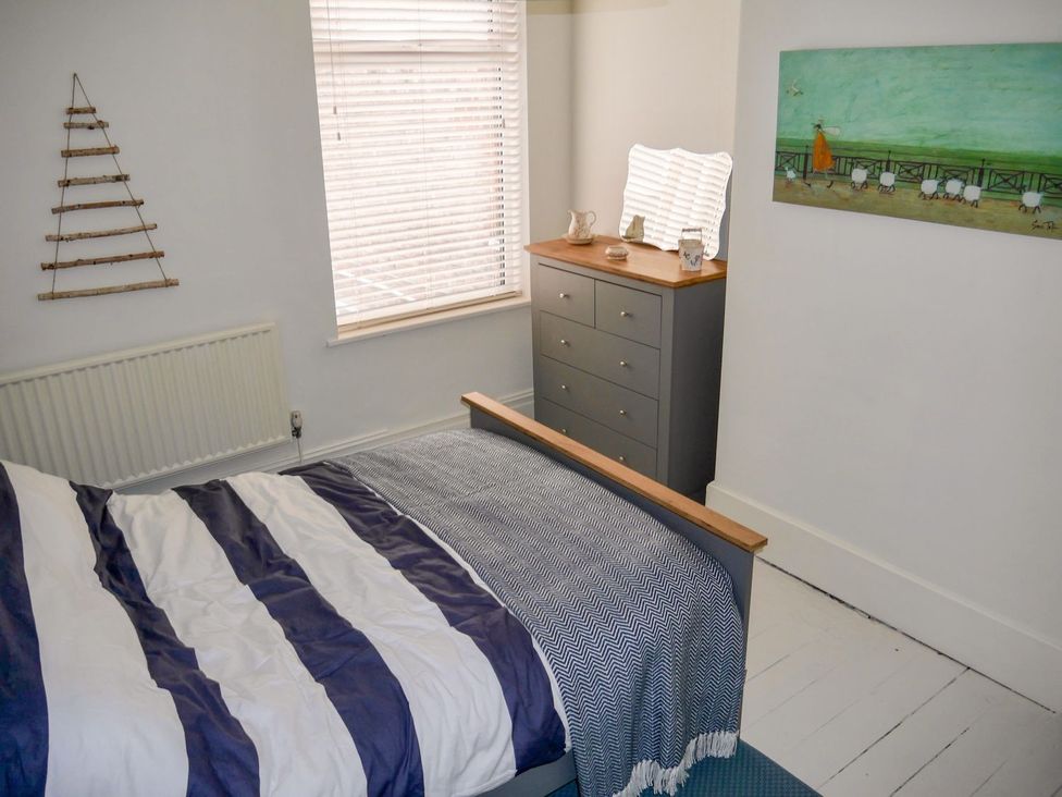 A bedroom with a bed and dresser at Anchor Cottage in Cleethorpes