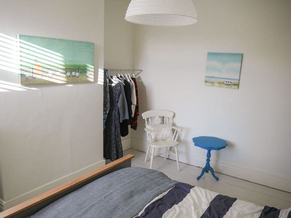A bedroom with a bed and clothes rack at Anchor Cottage Cleethorpes