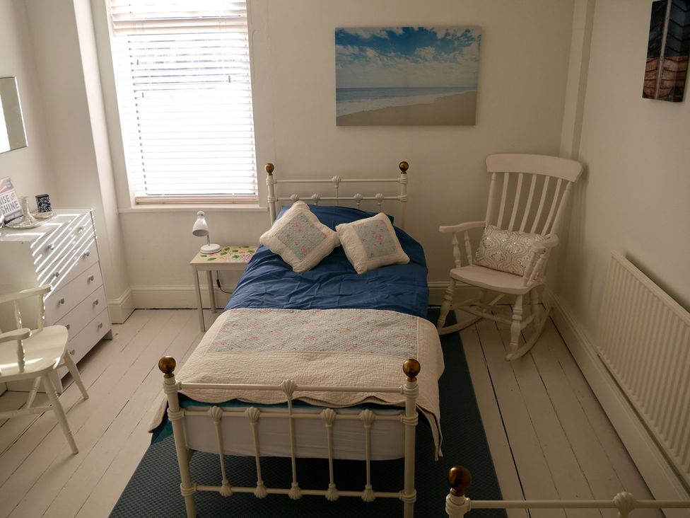 A bedroom with a bed and dresser at Anchor Cottage in Cleethorpes