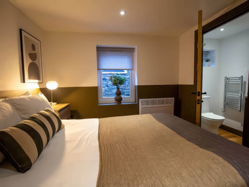 A bedroom with a bed and window at Beech Cottages in Llanrwst