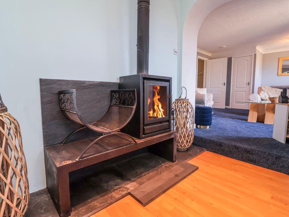 A living room with a fireplace and wood stove at Sea Spray Westward Ho!