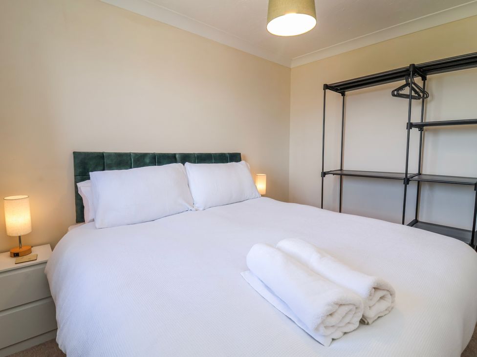 A bedroom with a bed and shelving unit at Sea Spray in Westward Ho!