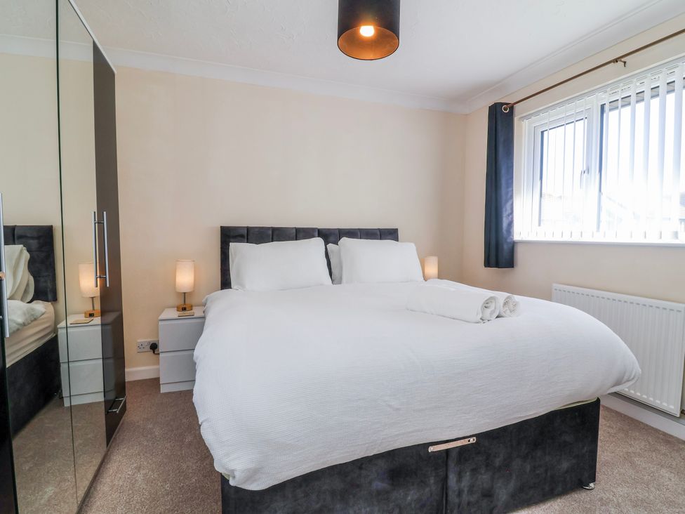 A bedroom with a bed and bedside table at Sea Spray in Westward Ho!