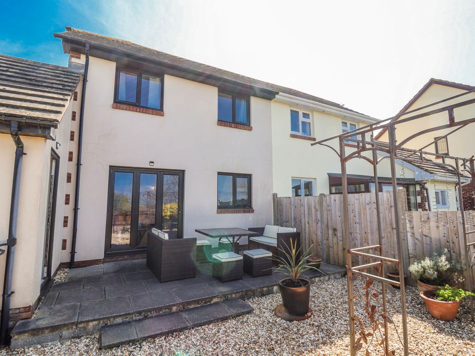 A garden with a patio area and seating at Sea Spray in Westward Ho!