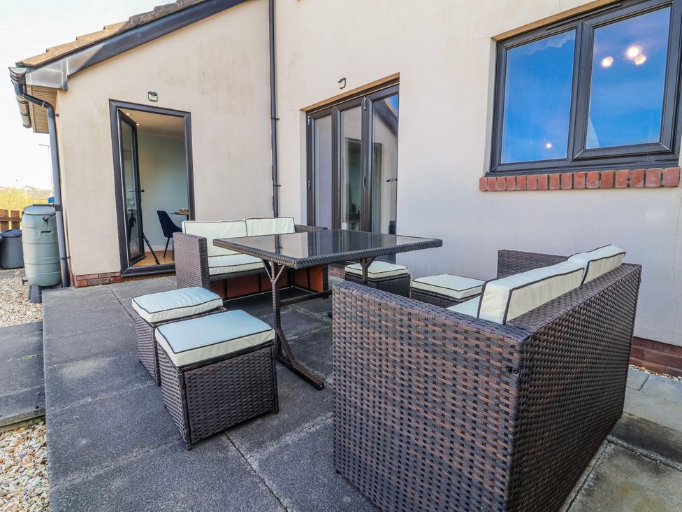 An outdoor seating area with a table and chairs at Sea Spray in Westward Ho!