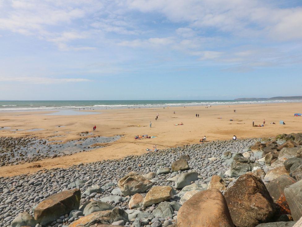 A beach with people enjoying the sand and water at Sea Spray in Westward Ho!