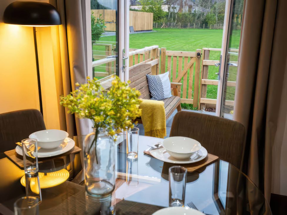 A dining room with a table and chairs at Fir Cottages in Llanrwst