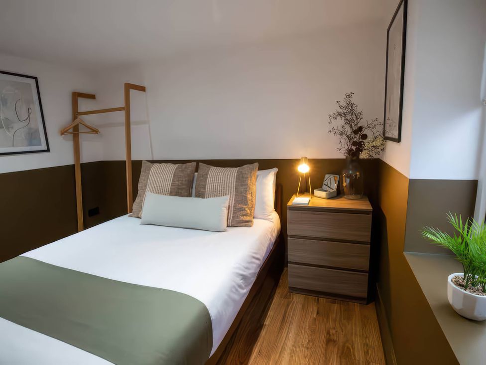 A bedroom with a bed and bedside table at Fir Cottages in Llanrwst