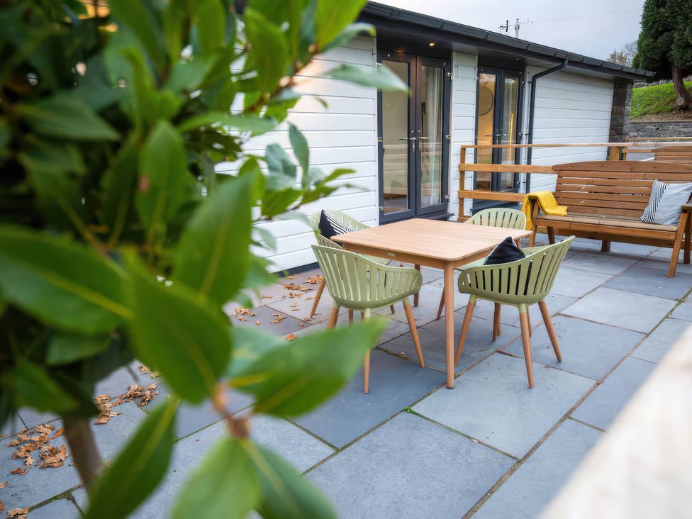 An outdoor seating area with a table and chairs at Fir Cottages in Llanrwst