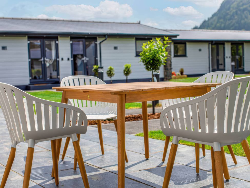 A table and chairs on a patio at Silver Birch Cottage in Llanrwst