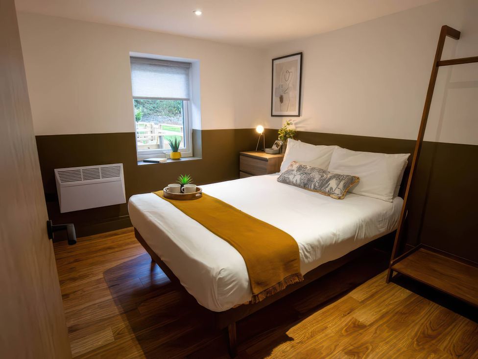 A bedroom with a bed and window at Silver Birch Cottage in Llanrwst