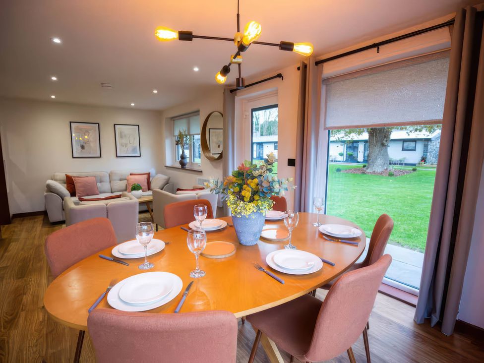 A dining room with a table set for four people at Mountain View Cottage in Llanrwst