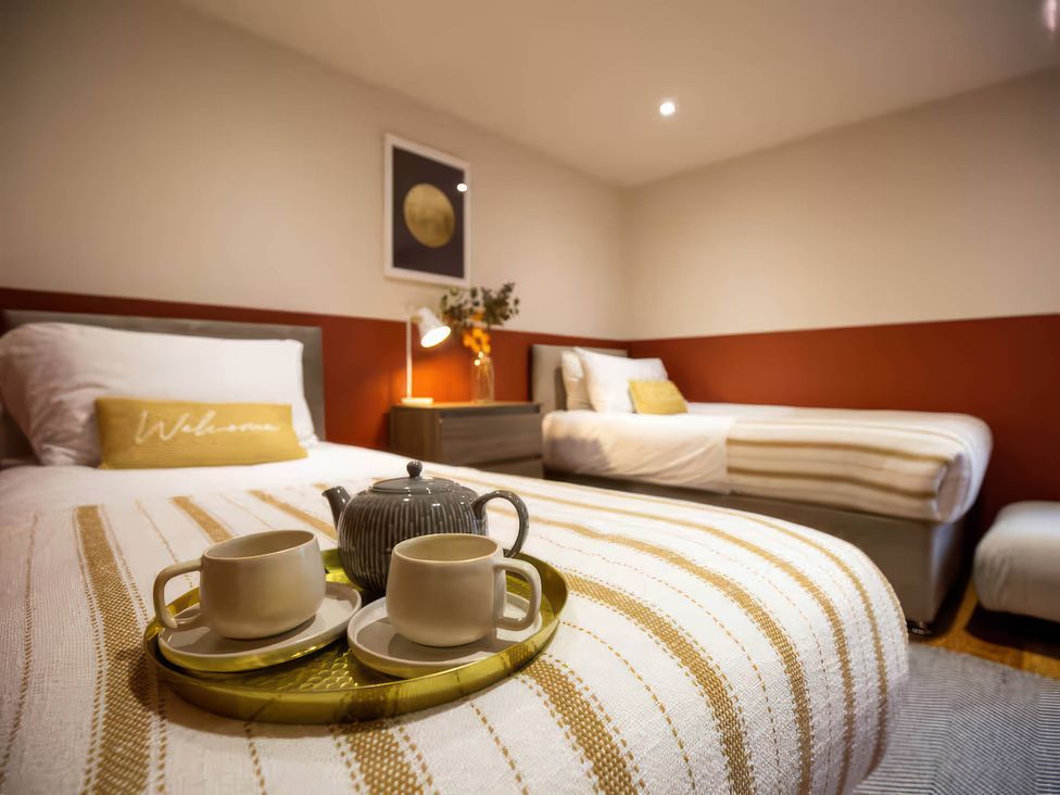 A bedroom with two beds and a tray with cups at Mountain View Cottage in Llanrwst