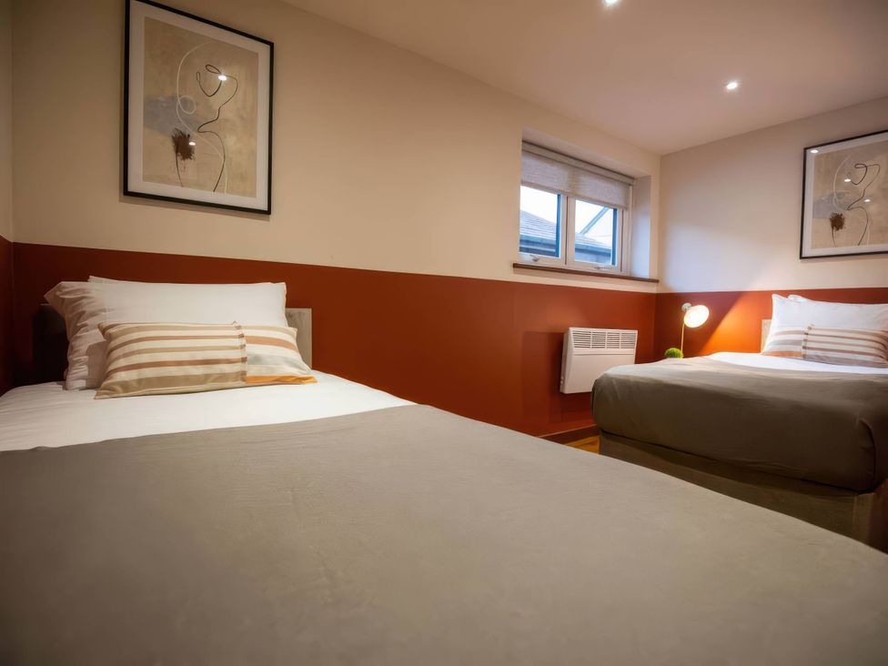 A bedroom with two beds and a window at Mountain View Cottage Llanrwst