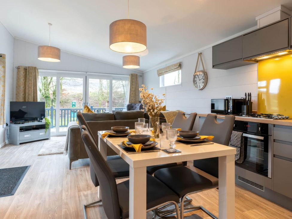An open plan kitchen and living area with dining table and sofa at The Falls Leyburn