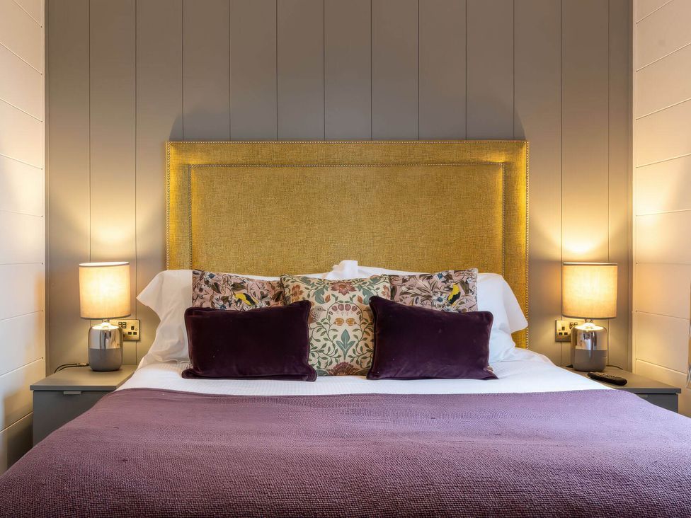 A bedroom with a bed and bedside lamps at The Falls in Leyburn