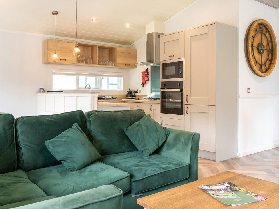 A kitchen with a green sofa and appliances at Wensleydale (Pet) Aysgarth
