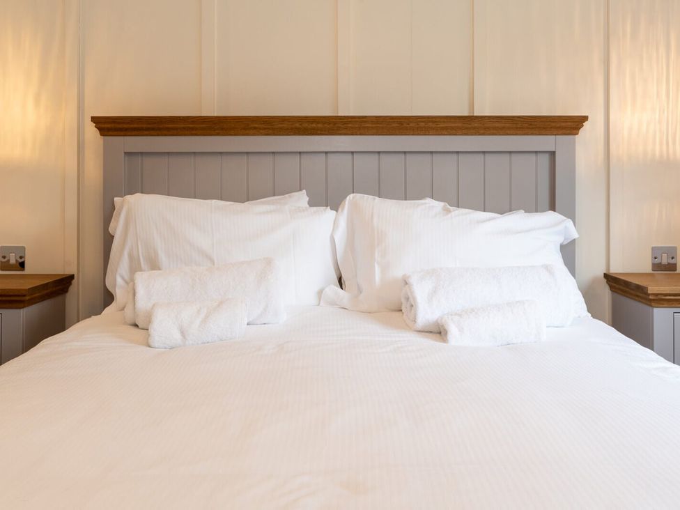 A bedroom with a bed and towels on the pillow at Wensleydale (Pet) Aysgarth