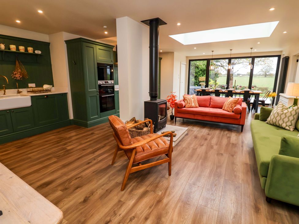 A living room with a stove and sofas at Fairview in Darsham