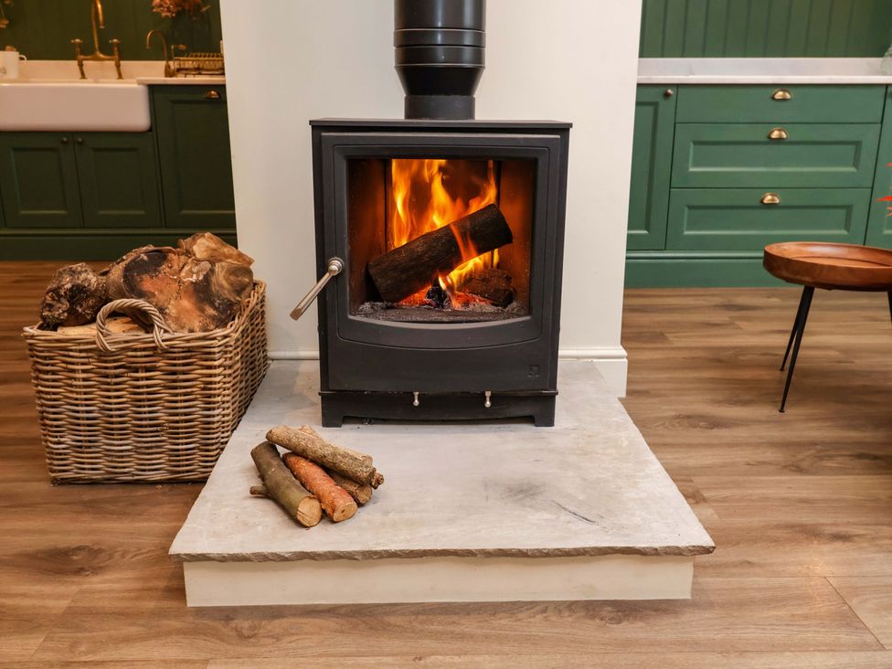 A fireplace with logs and basket in a living room at Fairview in Darsham