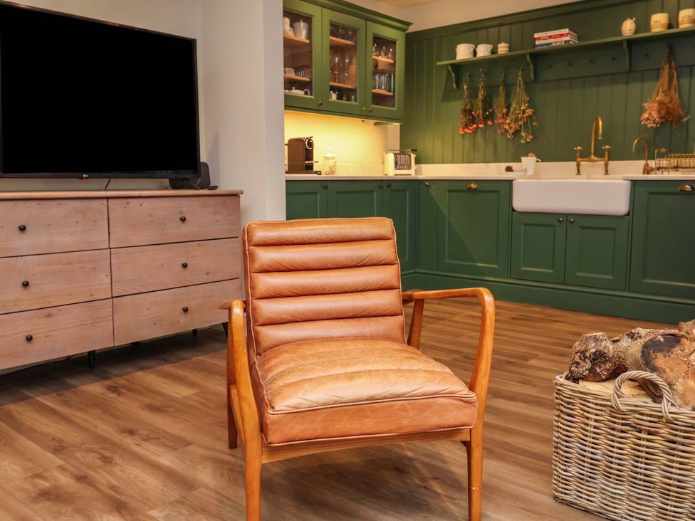 A kitchen with a chair and television at Fairview in Darsham
