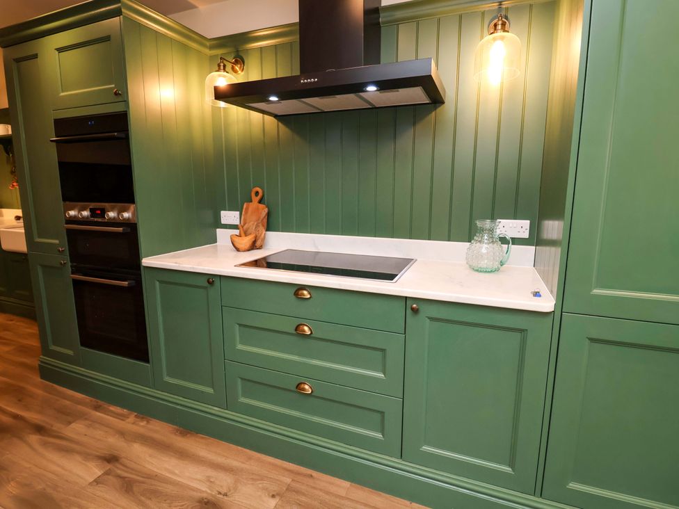 A kitchen with green cabinets and a stove at Fairview in Darsham